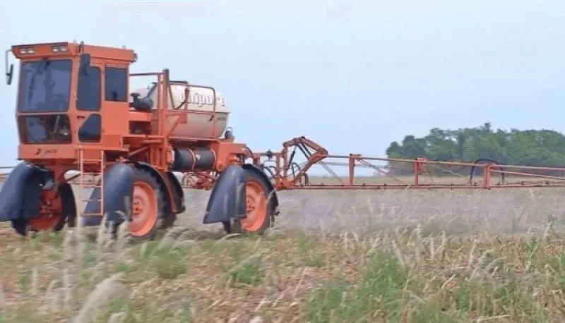 pulverizador autopropelido de grande porte, da marca Jacto e de cor laranja, em plena operação numa lavoura